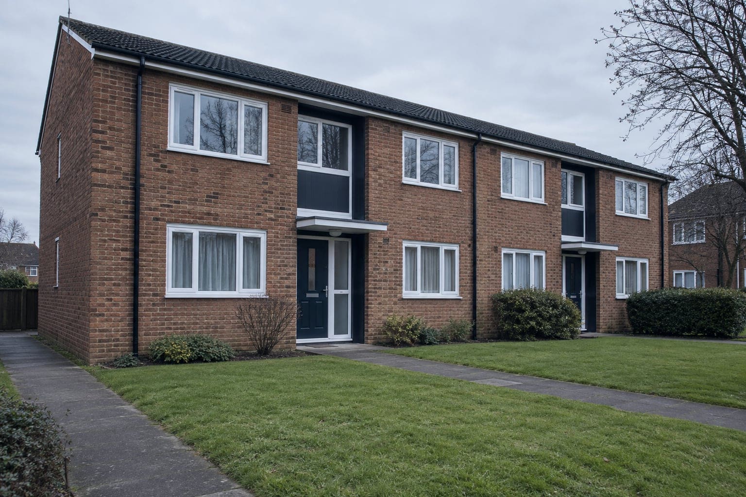 Well-kept low-rise brick council housing block with new windows and doors