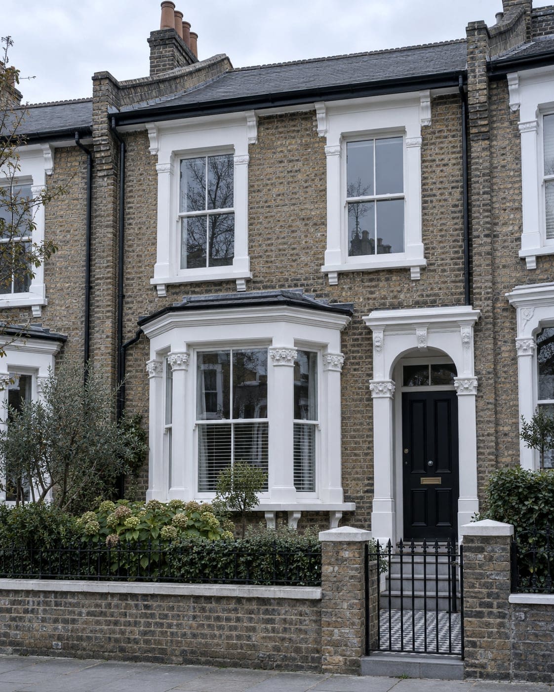 Restored London Victorian terraced house with new painted sash windows and black front door